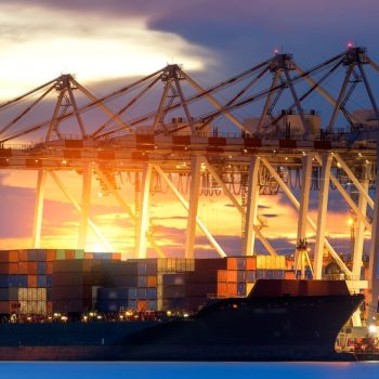 Container Cargo freight ship with working crane bridge in shipyard at dusk for Logistic Import Export background